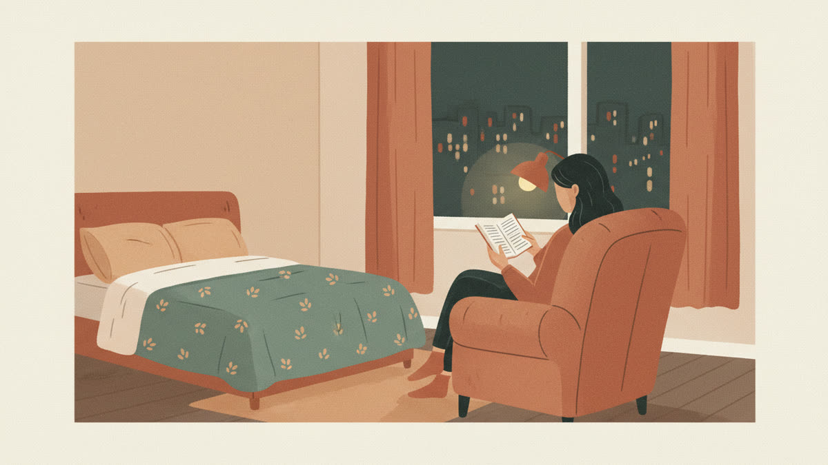 Женщина ночью читает бумажную книгу в кресле у окна под тёплой лампой, за окном огни города, рядом застеленная кровать